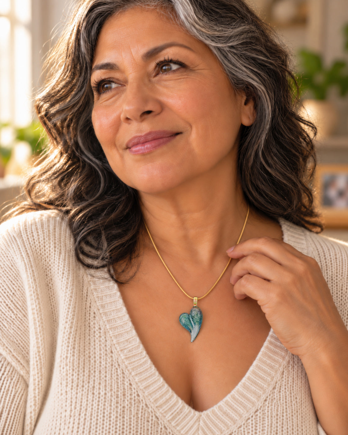 A woman wearing an Aquamarine glass heart cremation pendant made with a loved one's ashes