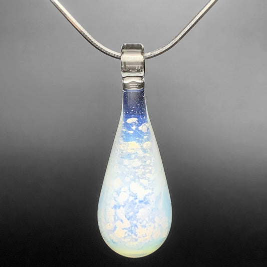An opaline glass teardrop pendant necklace infused with cremation ashes, showcased on a sturdy silver snake chain against a clean white background.